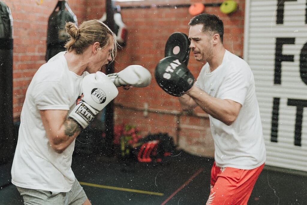 Home 18 two men sparring inside boxing gym